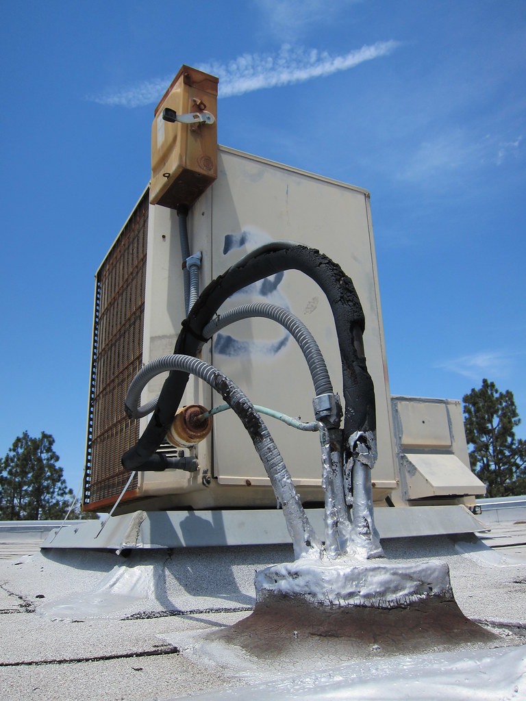 An aging outdoor condenser with refrigerant lines and a coil face