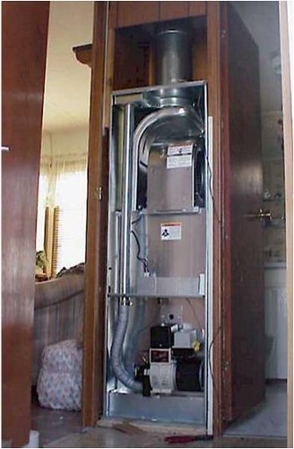 A gas furnace with the closet door open